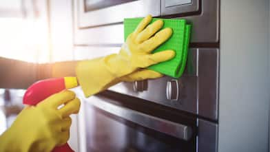 Hands cleaning stainless steel kitchen appliances  